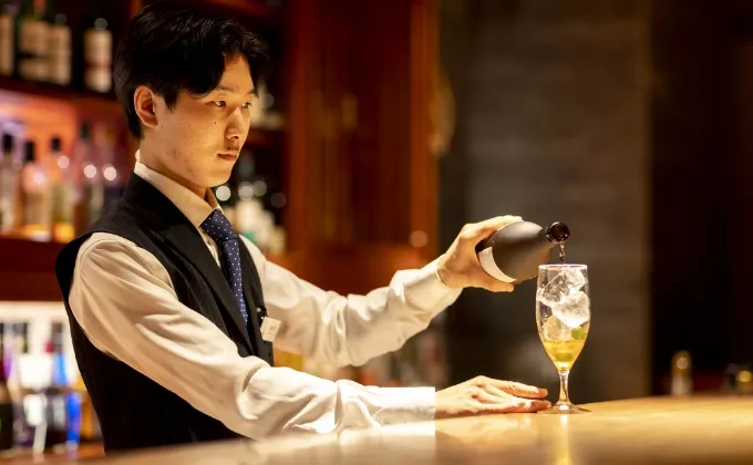 バーでお酒を注ぐバーテンダー